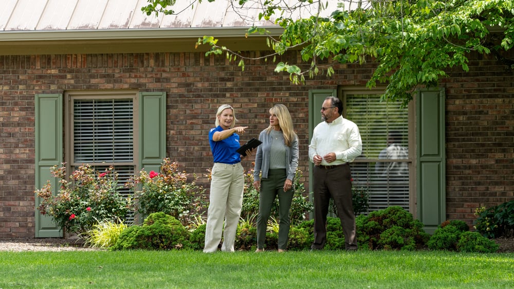 Man and woman assess property with Invisible Fence Installer