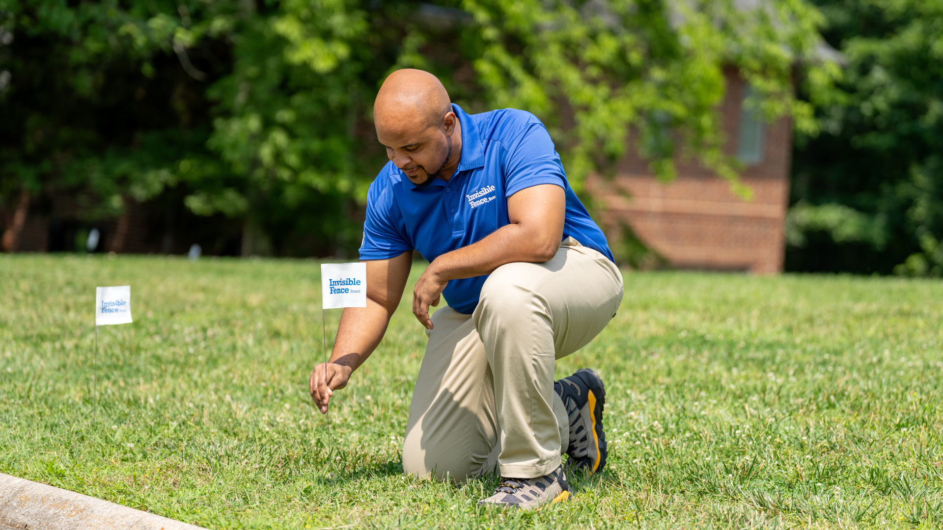 Invisible Fence technician places white flags in the ground to denote Invisible Fence boundary